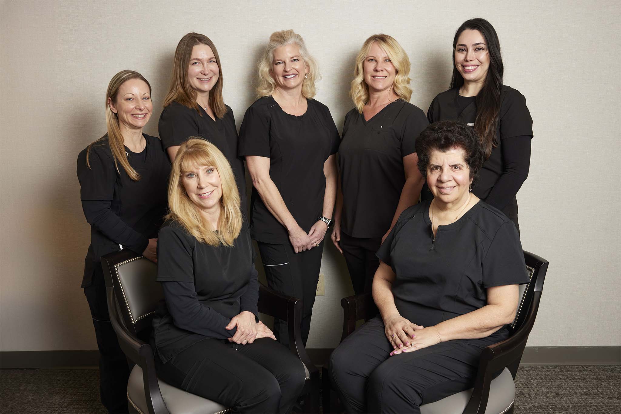 Nursing staff at Grosse Pointe Dermatology & Cosmetic Center, group of seven smiling nurses in black uniforms.