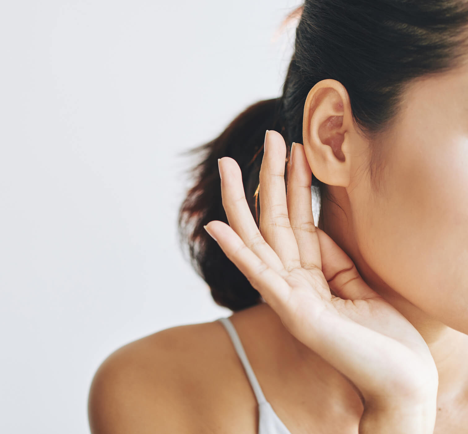 Close-up of an ear with a hand cupped behind it, illustrating common dermatology concerns of the ear.